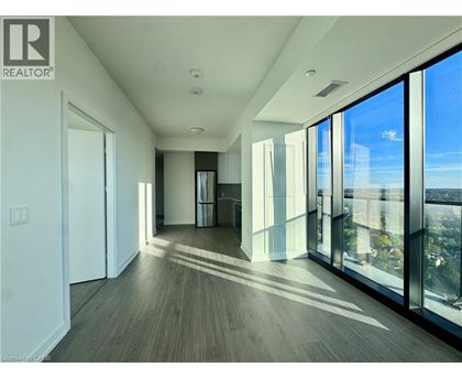 A spacious room with wooden floors and large windows.