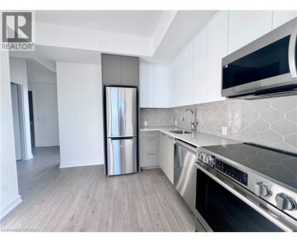 A modern kitchen with a stainless steel refrigerator and oven.
