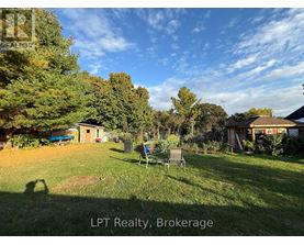 A backyard with a lawn chair and trees.