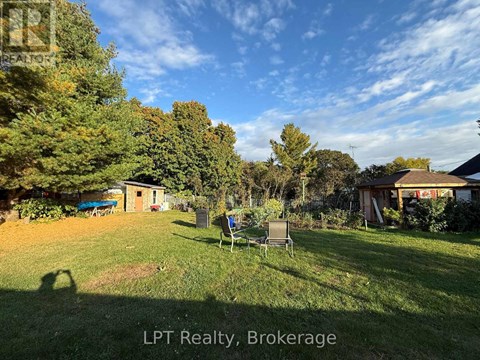 A backyard with a lawn chair and trees.