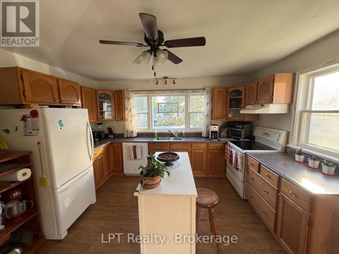 A kitchen with wooden cabinets and a white refrigerator.