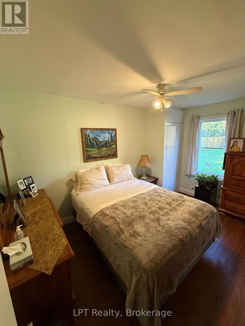 A bedroom with a bed, nightstand, and lamp.