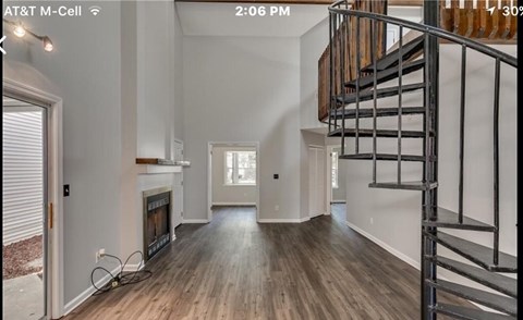 A modern interior with a wooden staircase and a fireplace.