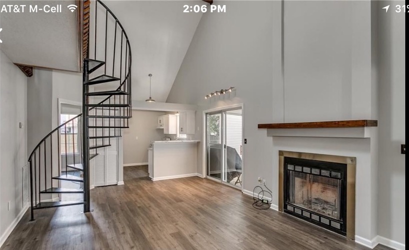 A modern living room with a spiral staircase and a fireplace.