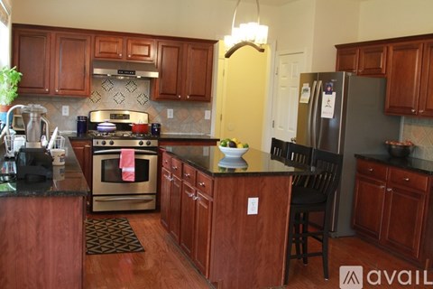 A kitchen with wooden cabinets and a black countertop.