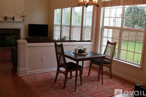 A dining room with a table and chairs.