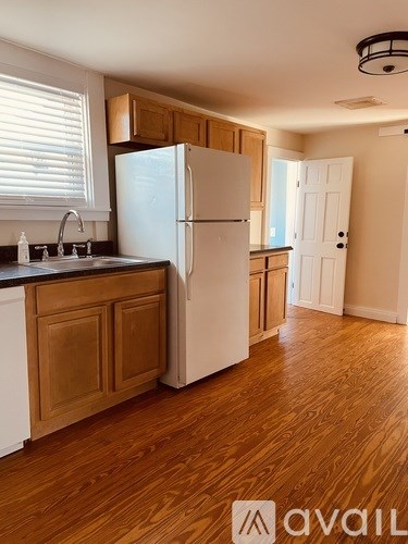 A kitchen with wooden cabinets and a white refrigerator.