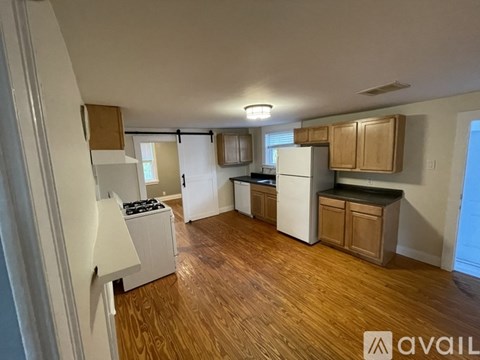 A kitchen with wooden floors and white appliances.