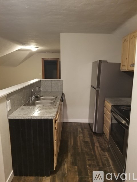 A kitchen with a black counter top and wooden cabinets.