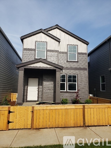 A grey house with a white door and windows.