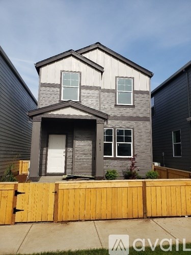 A grey house with a white door and windows.