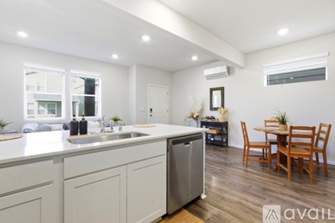 A kitchen with white cabinets and a wooden table.