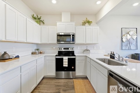 A kitchen with white cabinets and a stainless steel dishwasher.