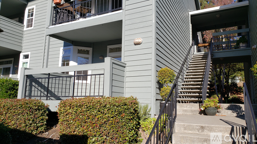 A grey building with a balcony and stairs.