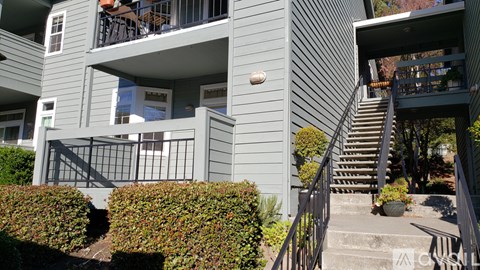 A grey building with a balcony and stairs.
