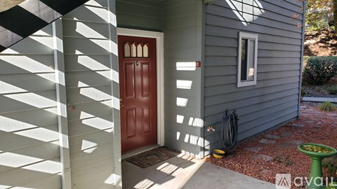 A house with a red door and a green planter.