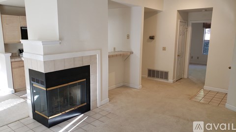 A living room with a fireplace and a carpet.