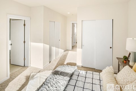 A bedroom with a bed in the center and a lamp on the side table.