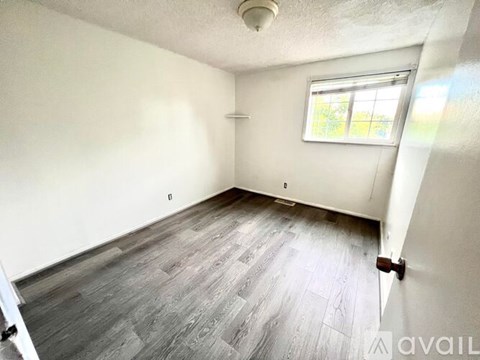 A room with a window and wooden flooring is available for rent.