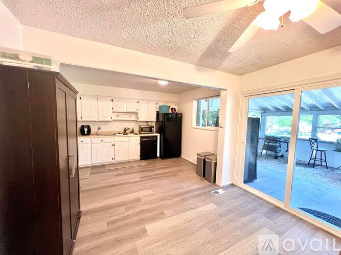 A kitchen with white cabinets and a wooden floor.
