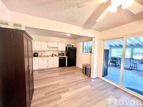 A kitchen with white cabinets and a wooden floor.