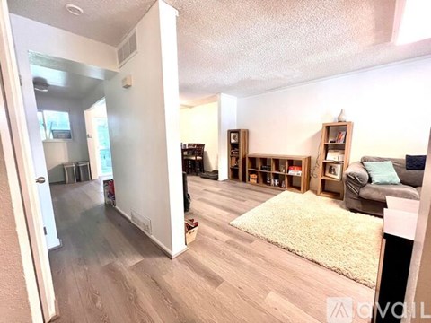 A living room with a couch, bookshelves, and a rug.