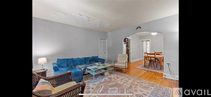 A living room with a blue couch and a rug.