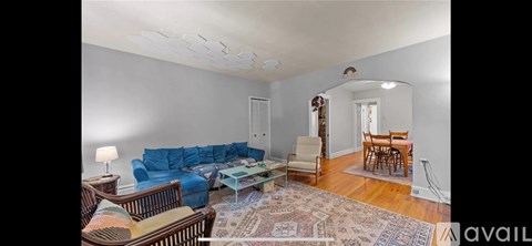 A living room with a blue couch and a rug.