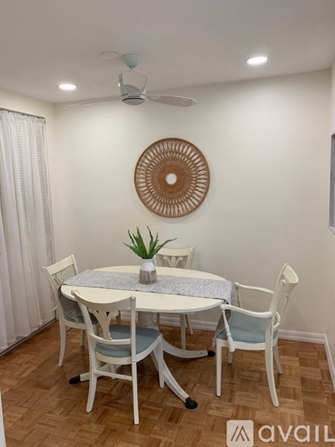 A dining room with a round table and chairs.