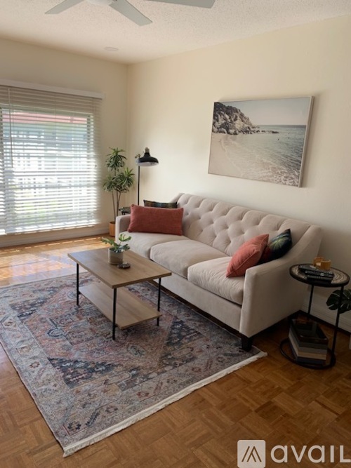A living room with a white couch, a coffee table, and a rug.