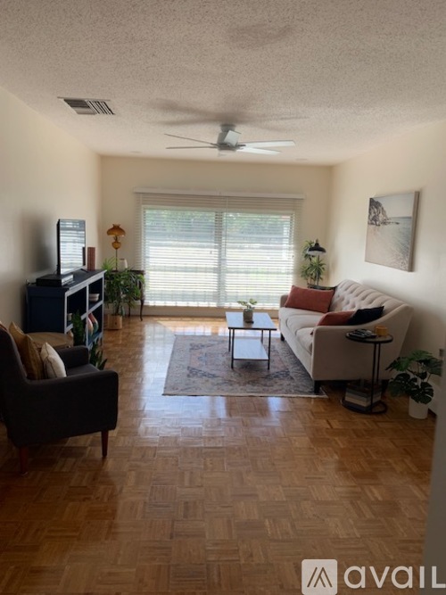 A living room with a couch, chair, and television.