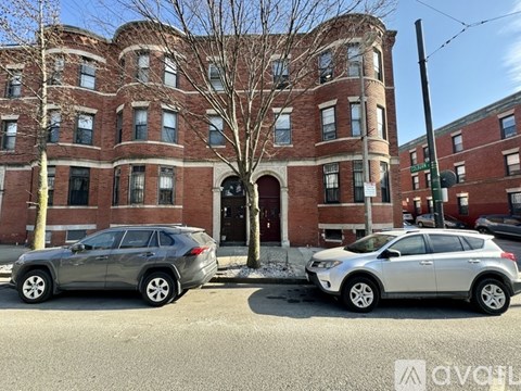 Two cars parked in front of a red brick building.
