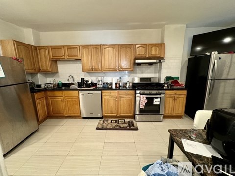 A kitchen with wooden cabinets and a black refrigerator.