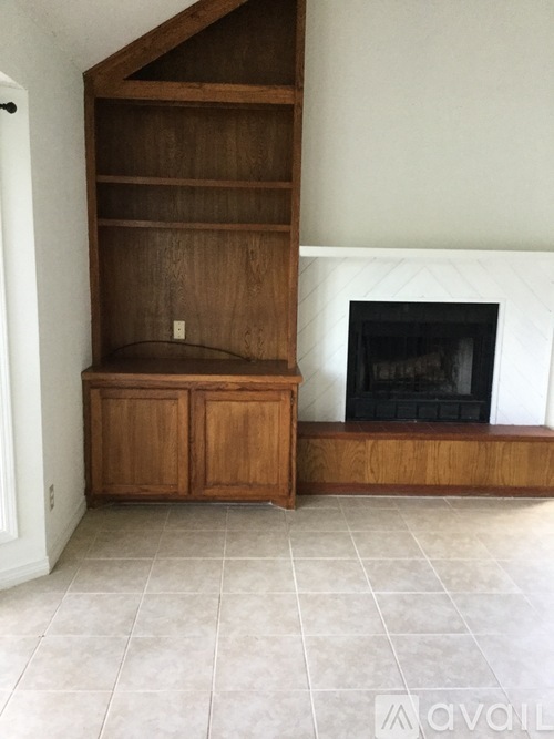 A room with a fireplace and a wooden cabinet.