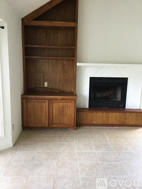 A room with a fireplace and a wooden cabinet.