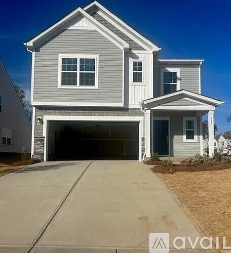 A two-story house with a garage is available for sale.