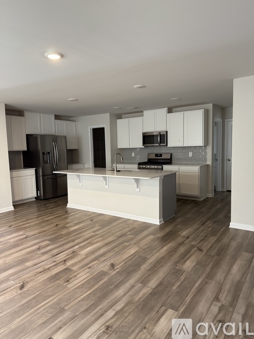 A kitchen with wooden floors and white cabinets.