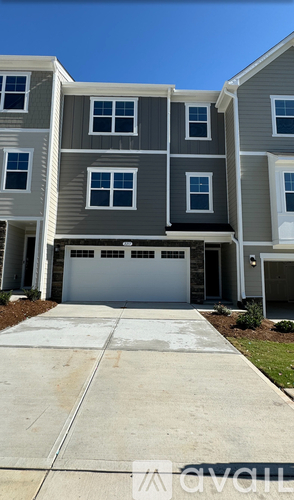 A modern two-story apartment building with a garage door in the front.