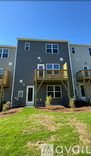 A row of houses with the word "AVAIL" written on the grass.