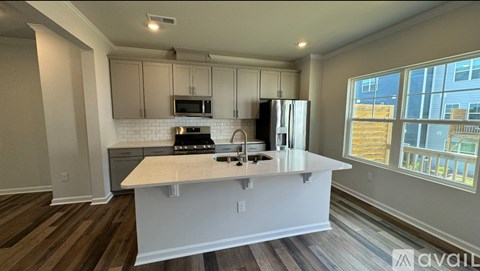 A kitchen with white cabinets and a white island with a sink.