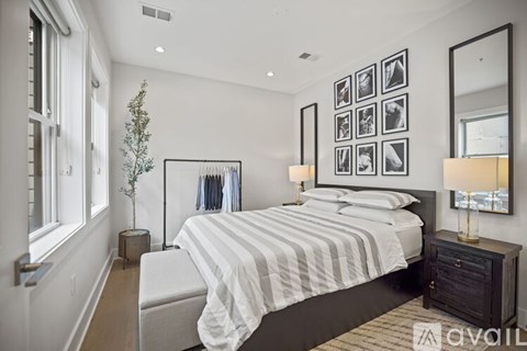 A bedroom with a bed, nightstand, and a mirror on the wall.