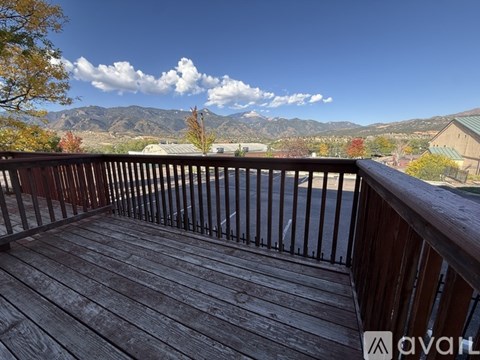 A wooden deck overlooks a mountain range.