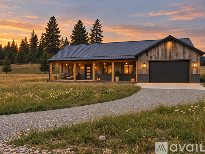 A house with a garage is surrounded by a gravel path and grassy field.