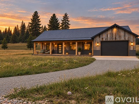 A house with a garage is surrounded by a gravel path and grassy field.