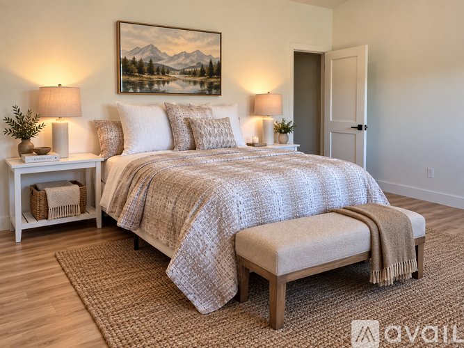A bedroom with a large bed and a painting of a mountain scene on the wall.