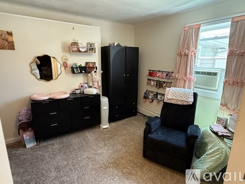 A room with a black dresser, a black chair, and a black cabinet.