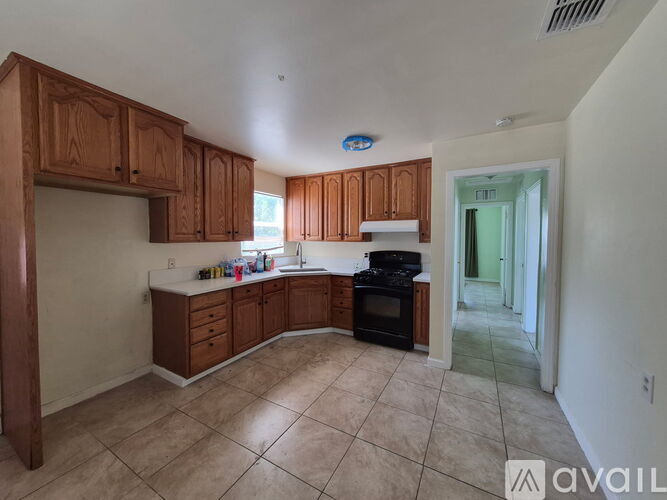 A kitchen with wooden cabinets and a black oven.