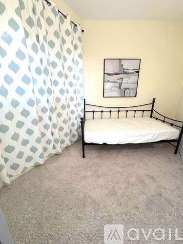 A bedroom with a bed and a picture on the wall.