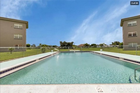 A swimming pool in front of two apartment buildings.