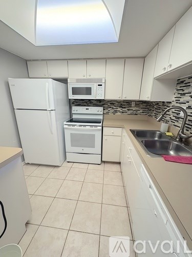 A kitchen with a white fridge, microwave, and dishwasher.